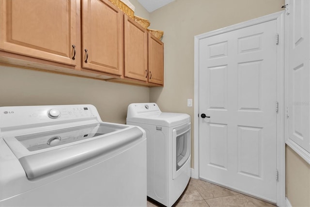 laundry room with cabinets, separate washer and dryer, and light tile patterned floors