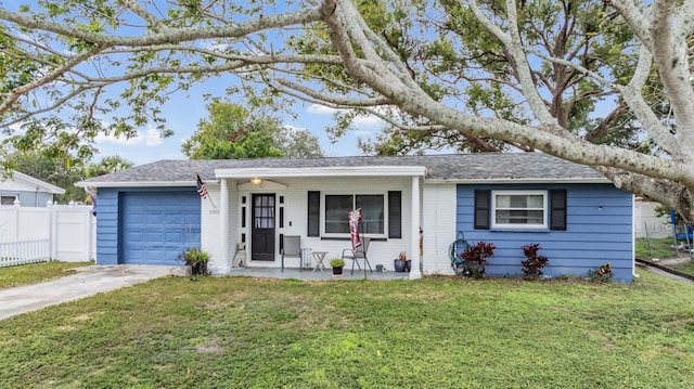 single story home with covered porch, a garage, and a front lawn