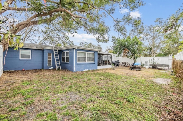 view of yard with a sunroom and a fire pit