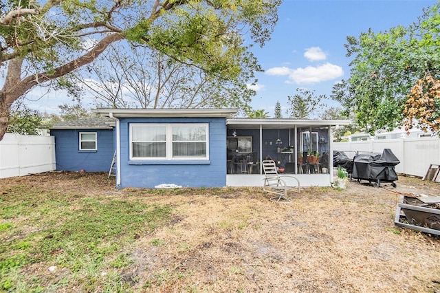 rear view of house with a sunroom and a yard