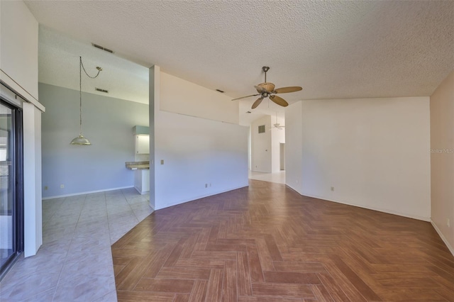 empty room featuring a textured ceiling, parquet flooring, ceiling fan, and vaulted ceiling