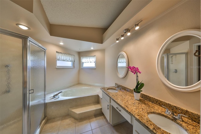 bathroom featuring tile patterned flooring, vanity, independent shower and bath, and a textured ceiling