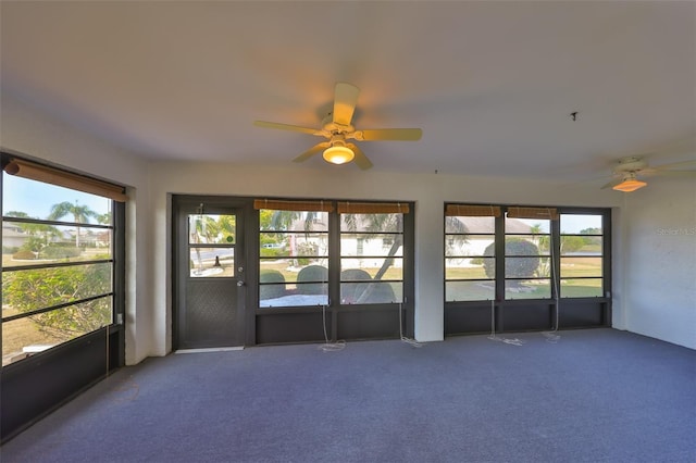 unfurnished sunroom featuring ceiling fan