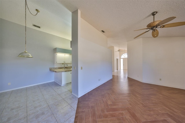 unfurnished room with light parquet floors, sink, a textured ceiling, and ceiling fan