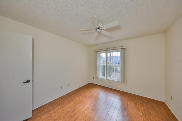 empty room with ceiling fan, light hardwood / wood-style floors, and a textured ceiling