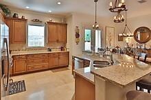 kitchen featuring a kitchen island, pendant lighting, a chandelier, a kitchen breakfast bar, and decorative backsplash