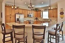 kitchen with decorative light fixtures, a breakfast bar area, and stainless steel appliances