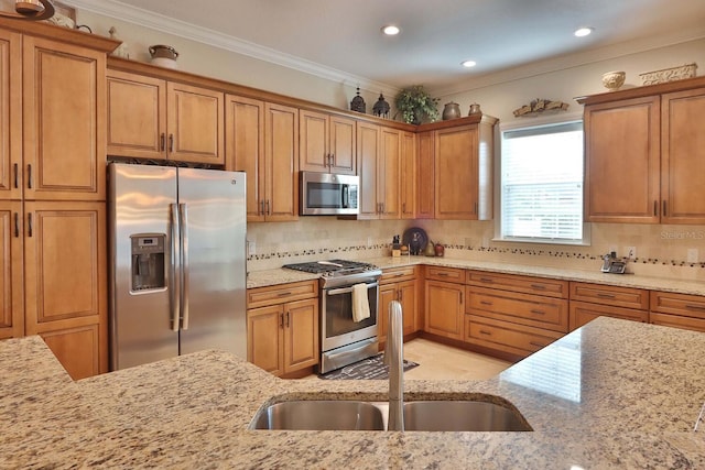 3222 W Empedrado St, Tampa, FL 33629 - kitchen with crown molding, appliances with stainless steel finishes, a sink, light stone counters, and brown cabinetry