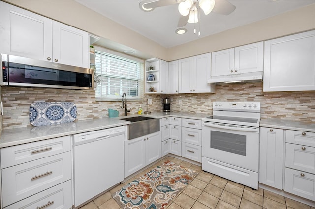 kitchen featuring white cabinetry, sink, white appliances, and light tile patterned floors