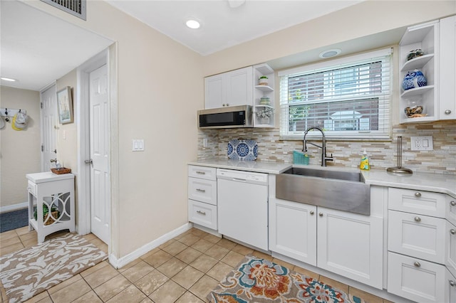 kitchen featuring sink, light tile patterned flooring, white cabinetry, and dishwasher