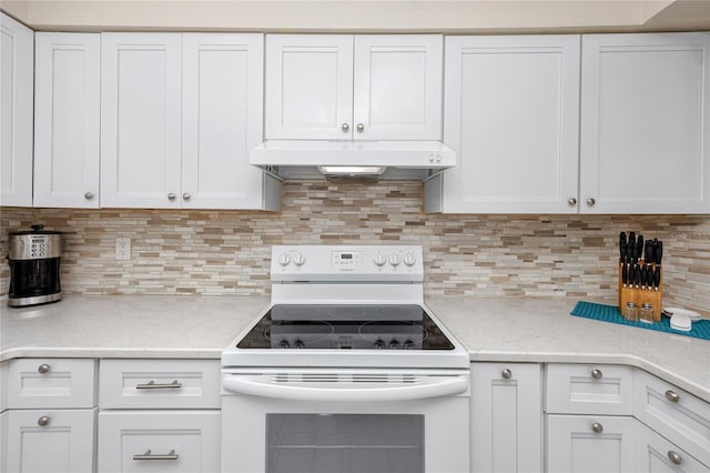 kitchen with white cabinets, tasteful backsplash, light stone countertops, and electric stove