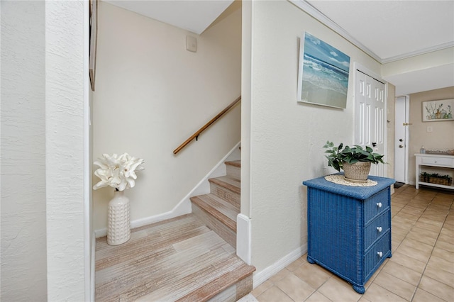 staircase with crown molding and tile patterned flooring