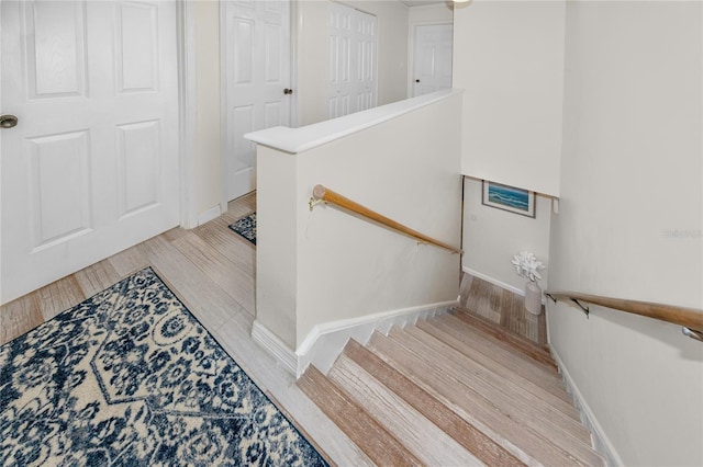 staircase with hardwood / wood-style flooring