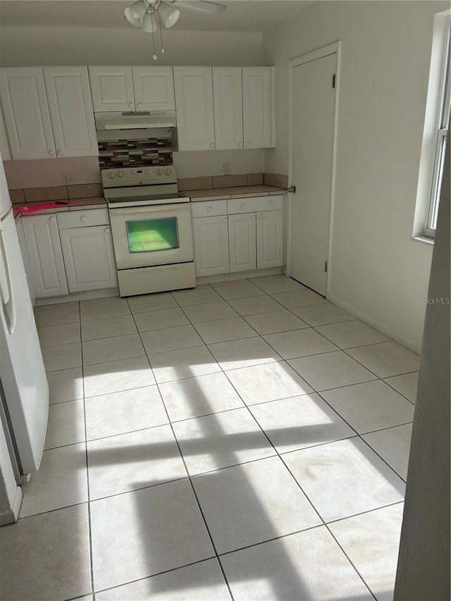 kitchen with white cabinets, white appliances, and light tile patterned flooring