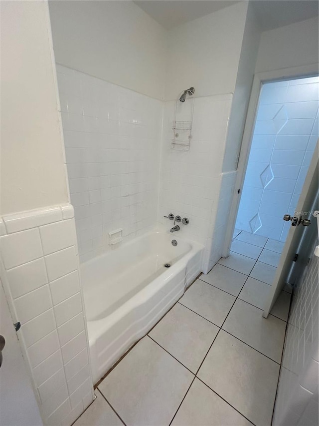 bathroom with tiled shower / bath, tile patterned flooring, and tile walls