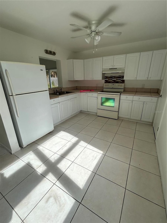 kitchen with ceiling fan, sink, white cabinets, light tile patterned flooring, and white appliances