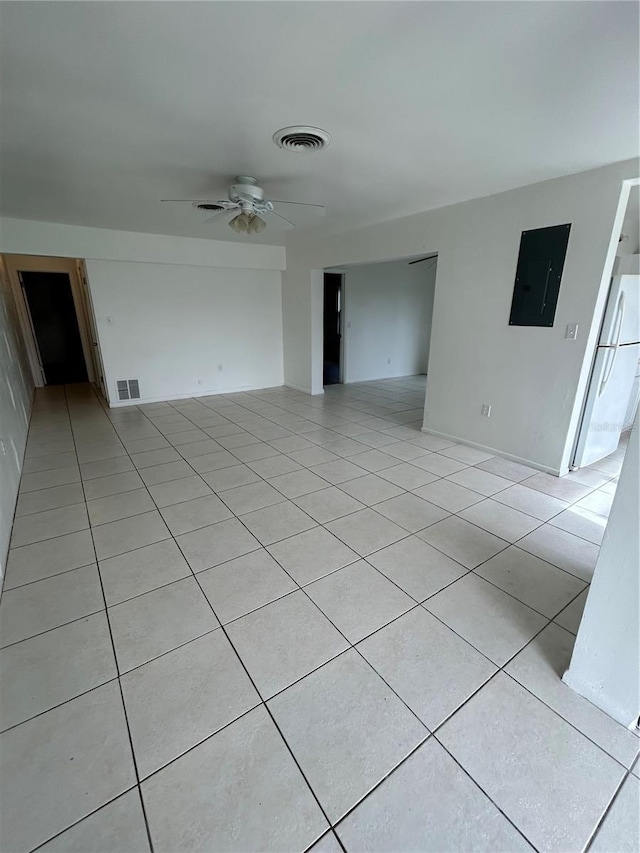 interior space with ceiling fan, light tile patterned floors, and electric panel