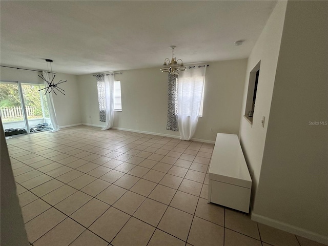 183 Bamboo Dr Unit B, Port Charlotte, FL 33954 - empty room with a chandelier, plenty of natural light, light tile patterned floors, and a smoke detector