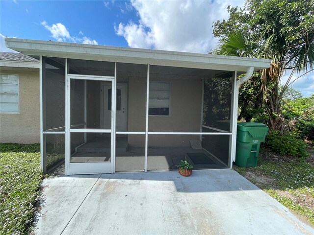 183 Bamboo Dr Unit B, Port Charlotte, FL 33954 - rear view of house featuring a sunroom and stucco siding