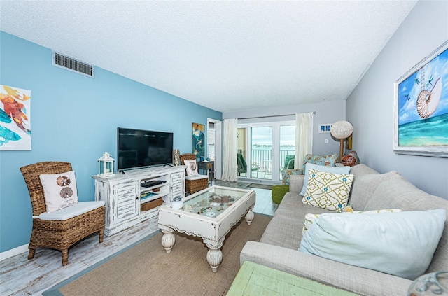 living room featuring light hardwood / wood-style floors and a textured ceiling