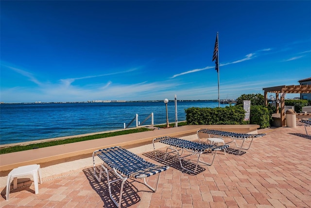 view of patio with a pergola and a water view