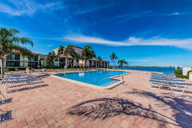 view of pool featuring a patio area and a water view