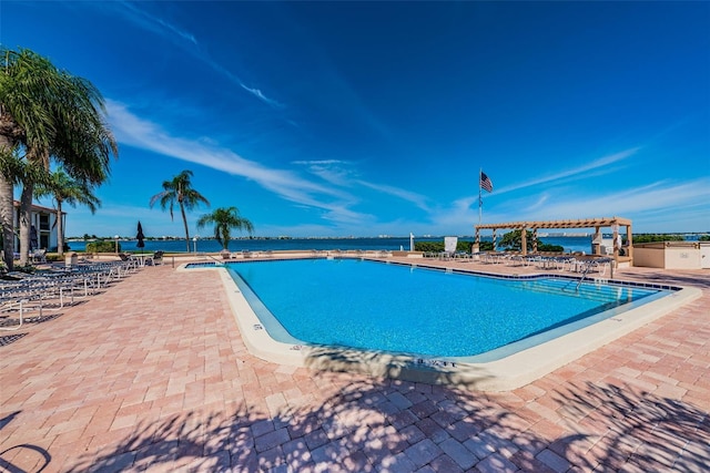 view of pool featuring a water view, a patio area, and a pergola