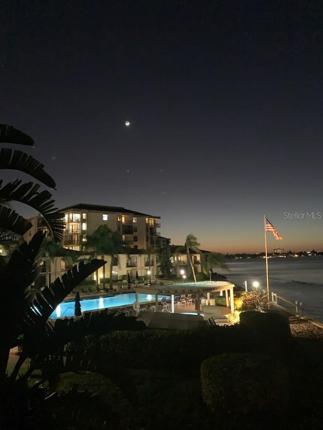 pool at twilight featuring a water view