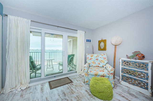 sitting room with hardwood / wood-style floors and a textured ceiling