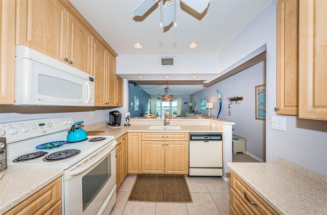 kitchen featuring sink, light brown cabinets, white appliances, and kitchen peninsula