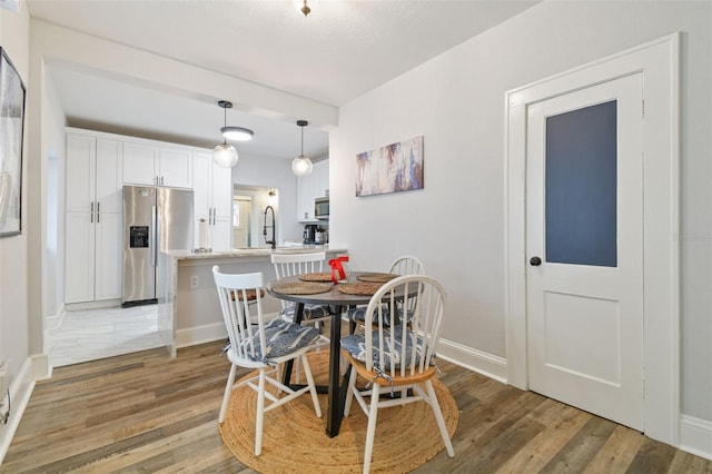 dining area with sink and hardwood / wood-style floors