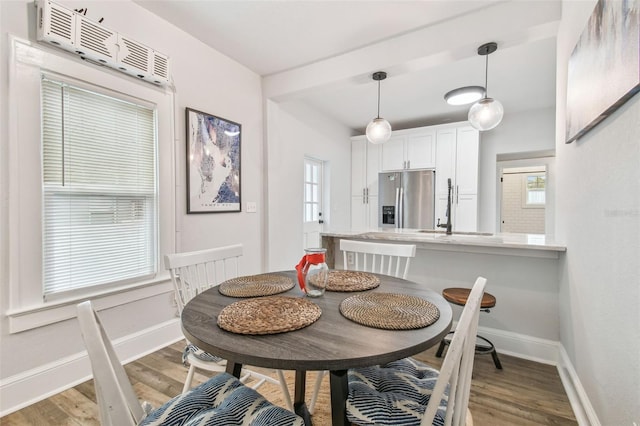 dining space featuring plenty of natural light, sink, and light wood-type flooring