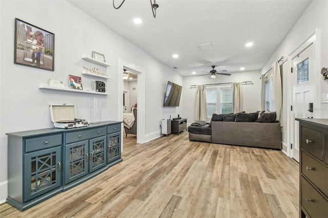 living room with ceiling fan and light hardwood / wood-style flooring