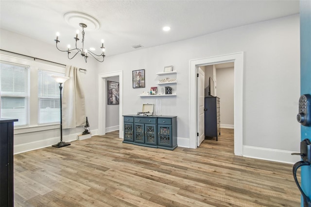 interior space featuring an inviting chandelier and light hardwood / wood-style flooring