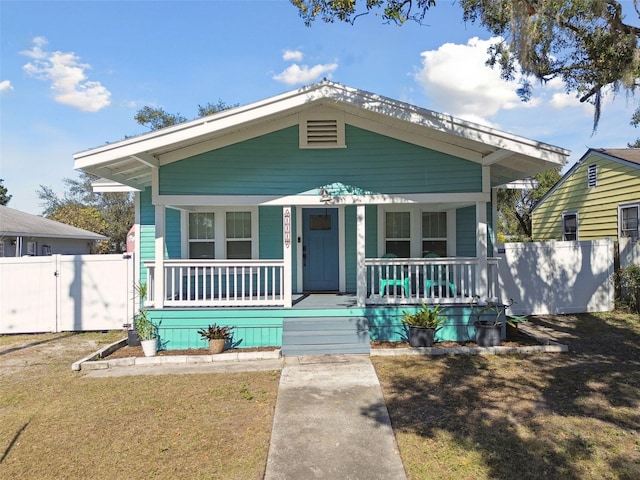 bungalow featuring a porch and a front lawn