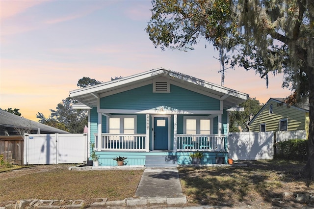 bungalow with a yard and covered porch