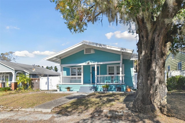 bungalow with covered porch and a front lawn