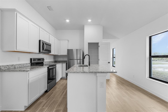 3418 Eagle Pass St, North Port, FL 34286 - kitchen with a center island with sink, a sink, visible vents, appliances with stainless steel finishes, and wood tiled floor