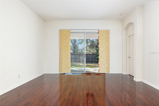 unfurnished room with dark wood-type flooring