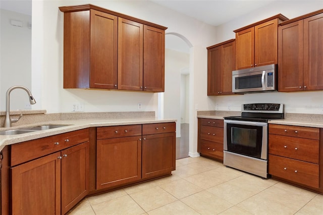 kitchen featuring sink, appliances with stainless steel finishes, and light tile patterned flooring