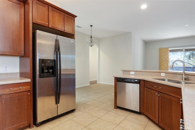 kitchen with sink, light tile patterned flooring, decorative light fixtures, and appliances with stainless steel finishes