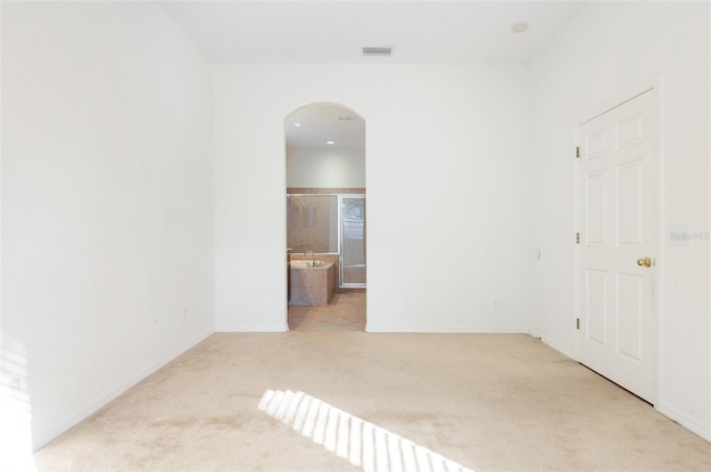 spare room featuring light colored carpet