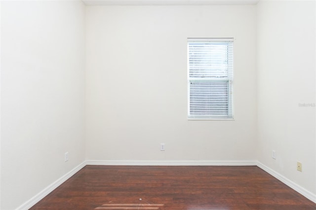 unfurnished room with dark wood-type flooring