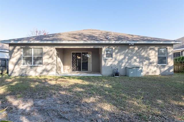 rear view of house featuring a patio and a yard