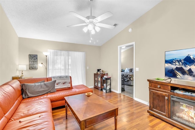 living room with light hardwood / wood-style flooring, vaulted ceiling, and ceiling fan