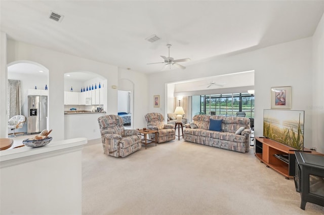 living room with ceiling fan and light colored carpet