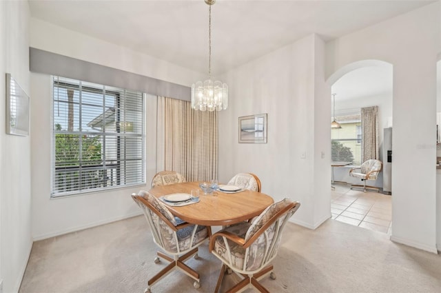 carpeted dining space featuring a notable chandelier