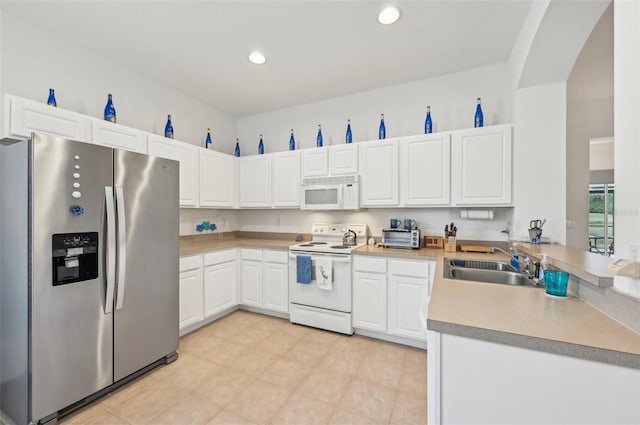 kitchen with white cabinetry, sink, white appliances, and light tile patterned floors