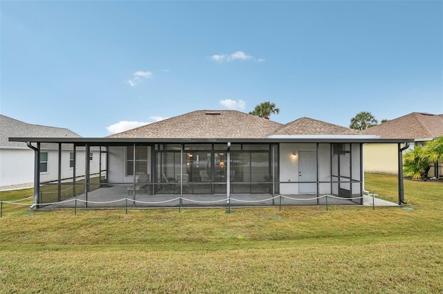 rear view of property with a yard and a sunroom