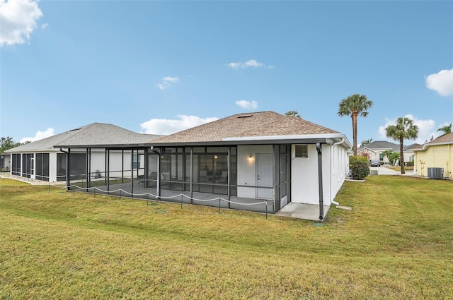 back of house featuring a yard, a sunroom, and central AC